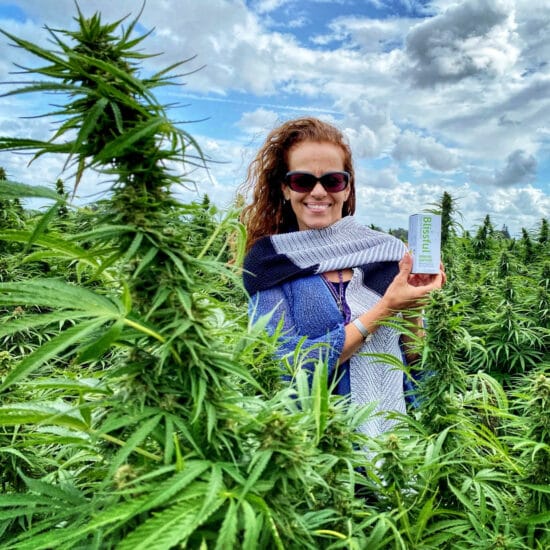 Lady Holding Blissful Plant Box in Hemp Field